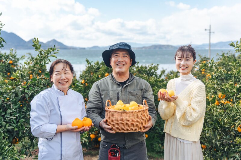 瀬戸田の柑橘畑で収穫した実をかかえる生産者